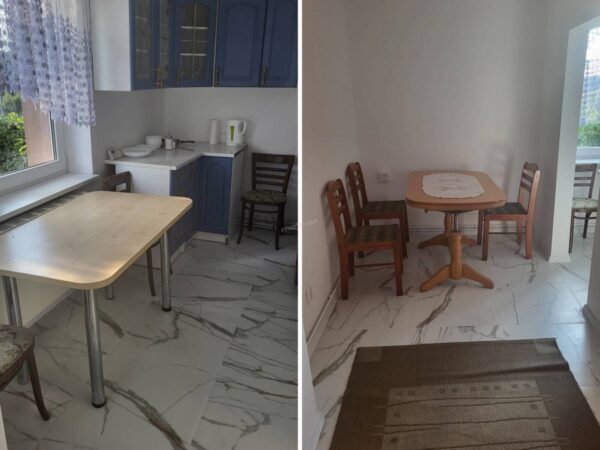 Small kitchen on left with blue cabinets, a light wooden table by a window, and chairs; right shows a corner dining area with a wooden table and matching chairs, lace runner, and marble floor.